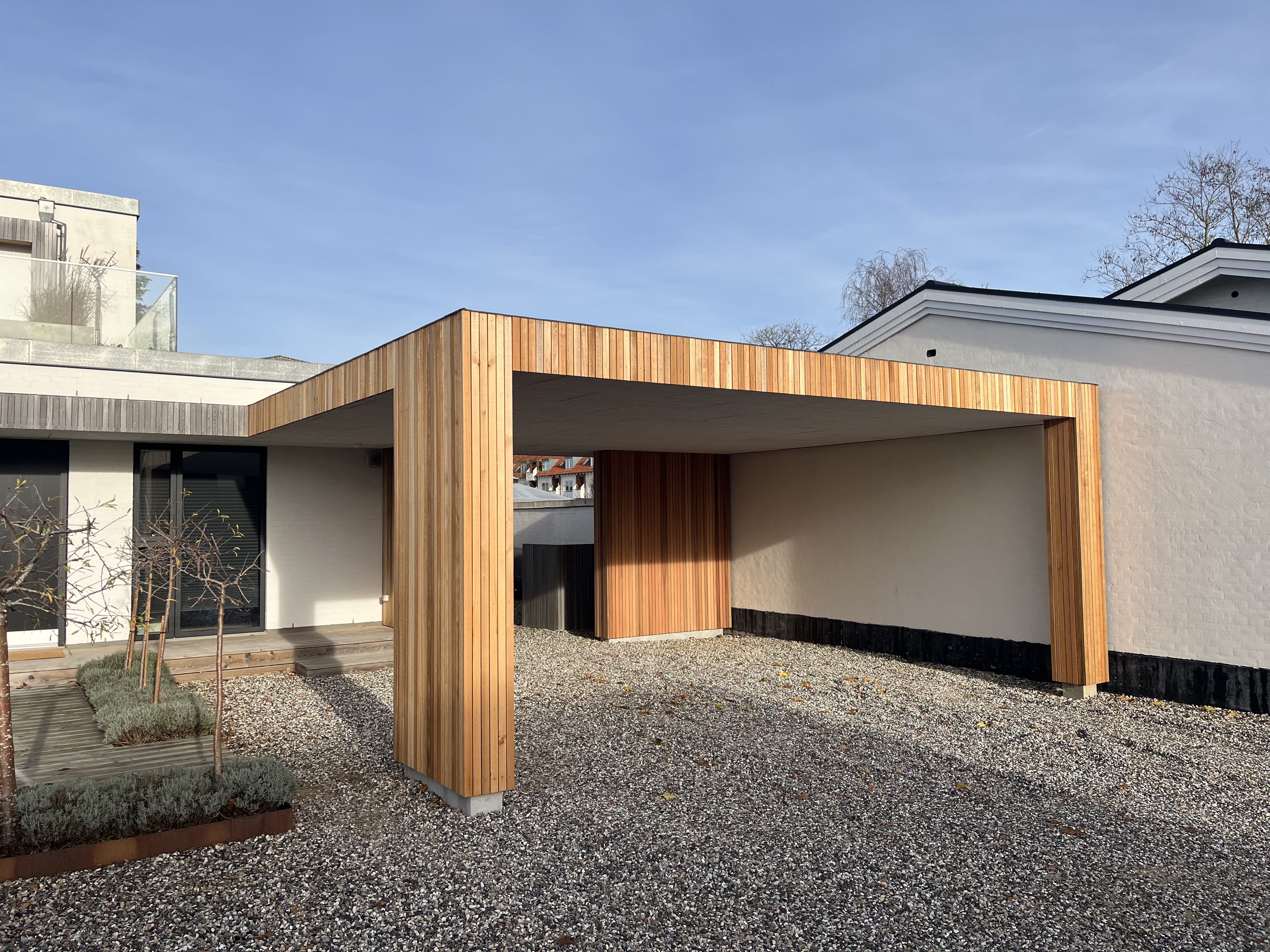 Tømrer bygger carport i træ ved et hus